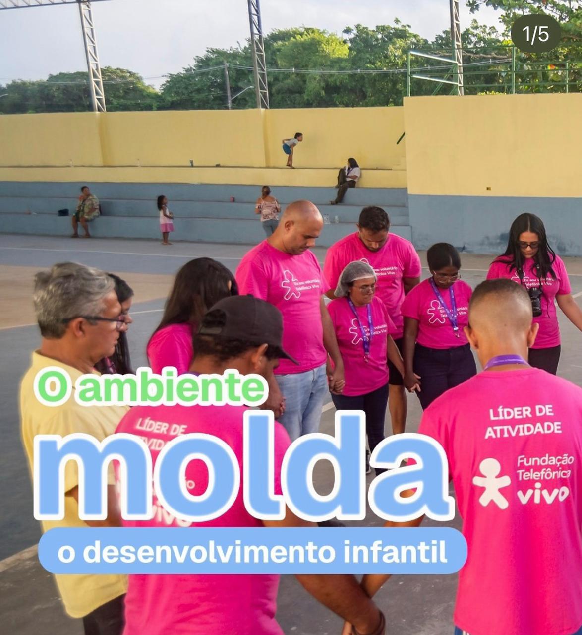 Equipe do Instituto em círculo de oração com voluntários e famílias
